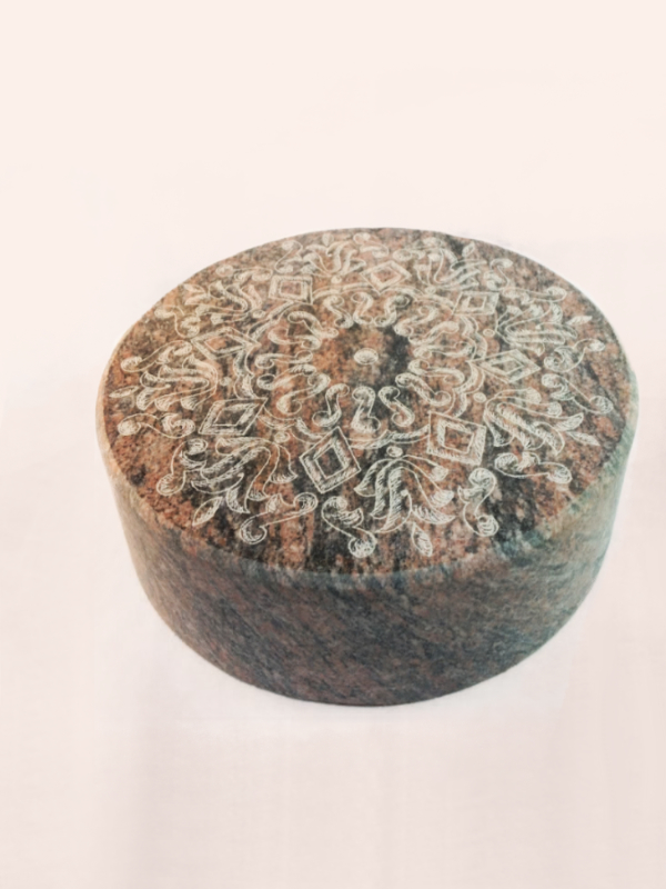 Auf den kreisrunde Stein aus Granit wurde von unserem syrischen Mitarbeiter Hany ein traditionelles orientalisches - Damaszener Ornament graviert. Er entwirft diese Ornamente selbst und schafft damit einzigartige Unikate in Stein. Mehr dazu erfahren Sie in unserem Blogartikel "Damastener Ornamente"